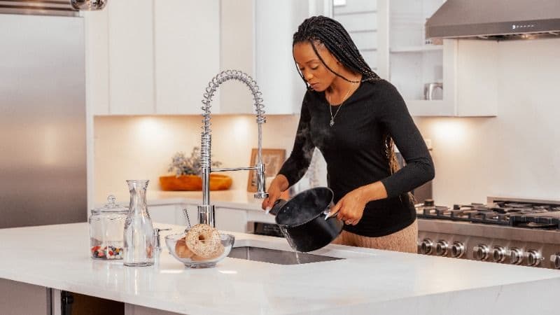 woman using the sink in her kitchen