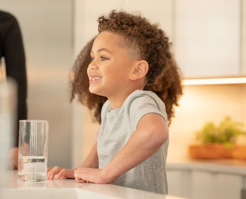 child standing in kitchen